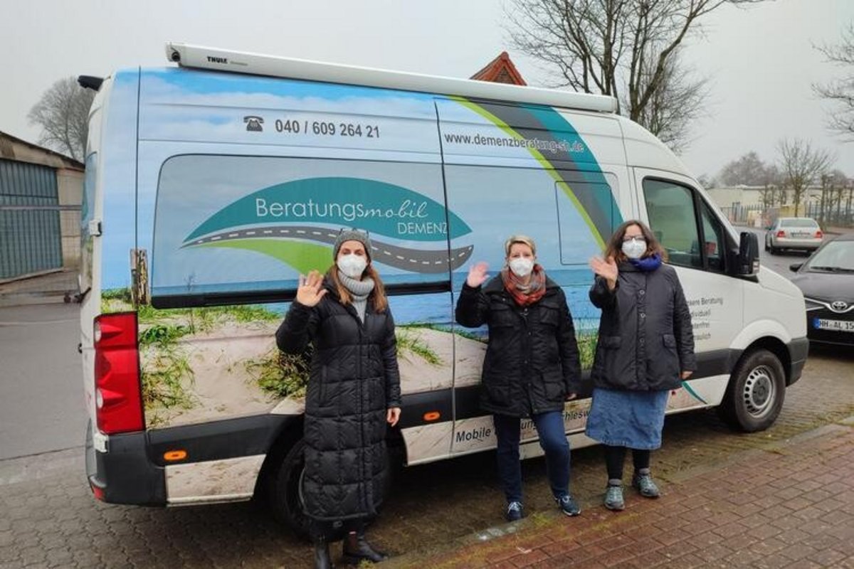 3 Frauen mit Mundschutz vor einem Lieferwagen