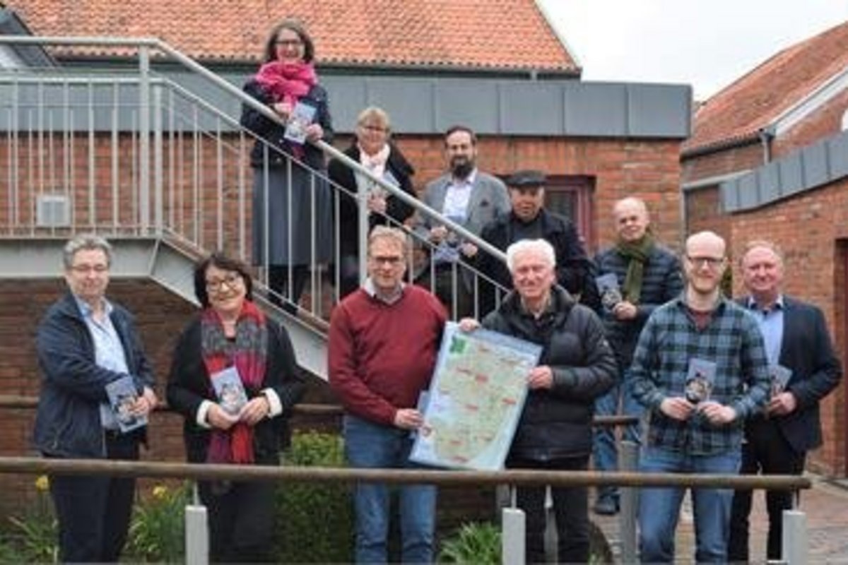 Gruppenbild von 11 Menschen vor und auf einer Treppe