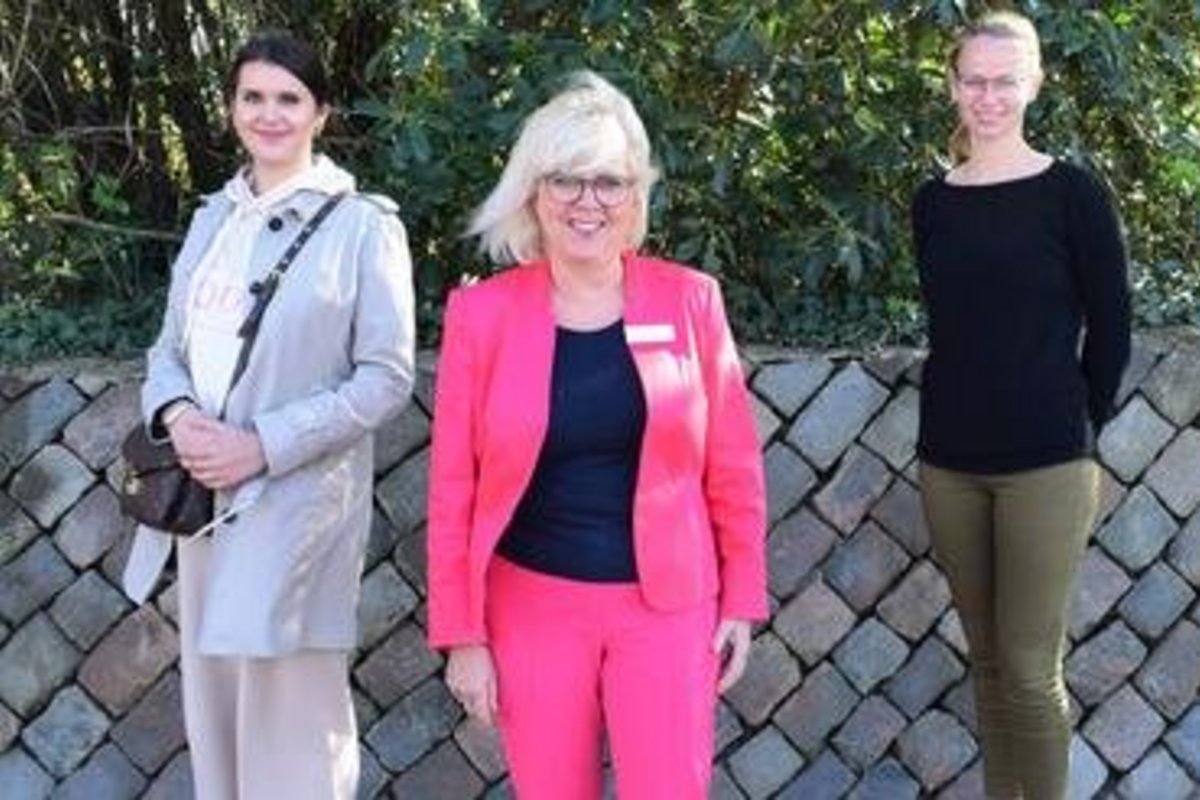 3 Frauen vor einer halbhohen Steinmauer